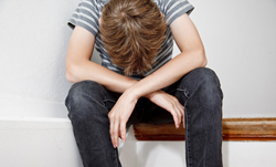 Boy crying while sitting on the stairs