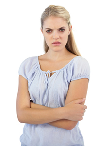 Outraged blonde woman with arms crossed on white background